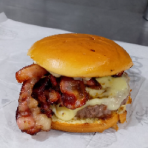 PÃO BRIOCHE,  MAIONESE,  CARNE ARTESANAL 180G,  QUEIJO MUSSARELA,  CEBOLA CARAMELIZADA,  FATIAS DE BACON DEFUMADO. ACOMPANHA FRITAS.